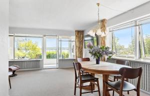 Un comedor con mesa y sillas y ventanas. en Stunning Home In Hobro, en Hobro