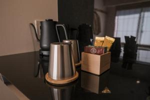 a counter top with two cups and a coffee maker at WAYFARER Shin in Kyoto