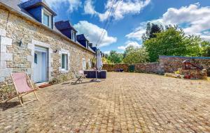a patio of a house with a chair and an umbrella at Nice Home In Plouagat With Wifi in Plouagat