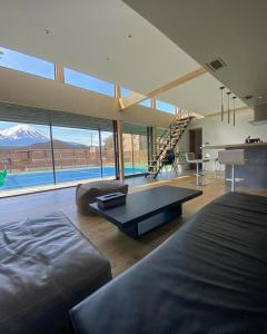 a large living room with a couch and a table at Mount Fuji view BBQ プライベートテニスコート付き高級リゾートヴィラ MAAA in Fujikawaguchiko