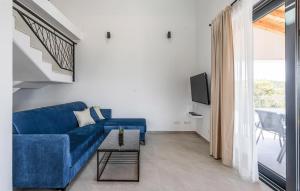 a living room with a blue couch and a tv at Stunning Home In Zman in Žman