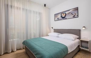 a bedroom with a bed and a large window at Awesome Apartment In Omisalj in Omišalj