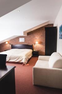 sypialnia z dużym łóżkiem i kanapą w obiekcie Hotel Purkmistr w Pilznie