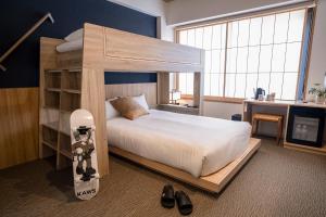 ein Schlafzimmer mit einem Etagenbett mit einem Snowboard darin in der Unterkunft WAYFARER Shin in Kyoto