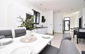 a white dining room with a white table and chairs at Nice Apartment In Brodarica With Sauna in Brodarica