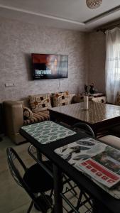 una sala de estar con una mesa y un sofá en Logement Sable et Vagues, en Saidia  8 fotos más