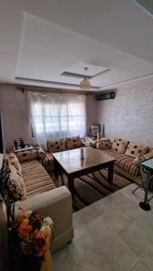 Una sala de estar con sofás y una mesa. en Logement Sable et Vagues, en Saidia 