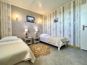 ein Schlafzimmer mit 2 Betten und einem Kreuz an der Wand in der Unterkunft Maison familiale à La Brée-les-Bains - 3 chambres, terrasse, près de la plage - FR-1-246A-318 in La Brée-les-Bains