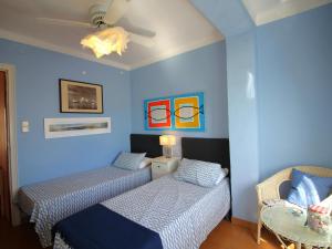 zwei Betten in einem Zimmer mit blauen Wänden in der Unterkunft Ático acogedor con gran terraza cerca de la playa de La Farella, Llançà - ES-228-191 in Llança