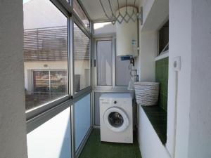 eine Waschküche mit einer Waschmaschine und einem Fenster in der Unterkunft Ático acogedor con gran terraza cerca de la playa de La Farella, Llançà - ES-228-191 in Llança