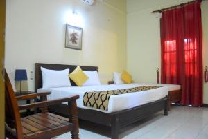 a bedroom with a large bed with a red curtain at Osara Holiday Home in Anuradhapura