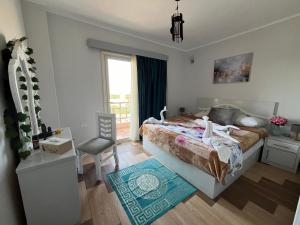 una camera da letto con un letto, una sedia e una finestra di PortghalibFlat a Port Ghalib