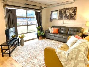 a living room with a leather couch and a television at Suite Dreams in Cedar City
