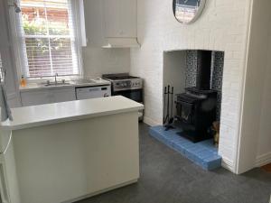 a kitchen with a stove and a fireplace at Kilparney House in Benalla +8 photos