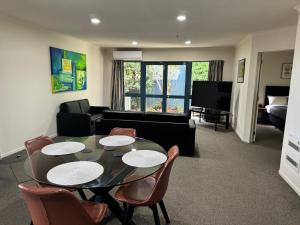 a living room with a table and chairs and a couch at Bassingers Motor Lodge in Levin