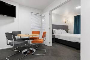 a hotel room with a bed and a table and chairs at Lakeview Colonial Motel in Queenstown