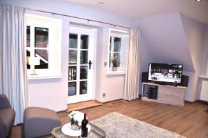 a living room with a tv and two windows at Ferienwohnung Stedden in Stedden