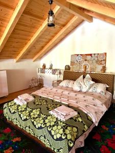 a bedroom with a large bed in a attic at Pensiunea Casa Țărănească in Satu Bătrîn