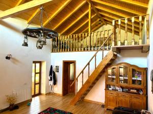 a living room with a wooden staircase and a stair case at Pensiunea Casa Țărănească in Satu Bătrîn