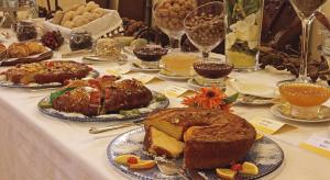 uma mesa com vários tipos diferentes de bolos e sobremesas em Hotel Real d Obidos em Óbidos