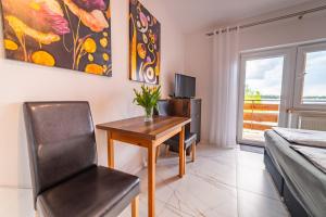 a bedroom with a table and a chair and a bed at Apartamenty i pokoje Seeblick in Mikołajki