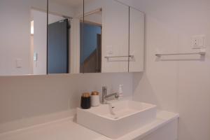 a white bathroom with a sink and a mirror at Mova Villa Koshi Misawa south in Kikutomi +25 photos