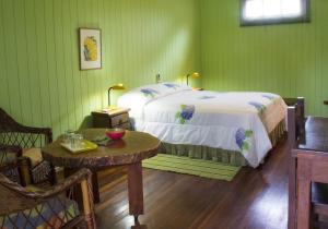 Dormitorio verde con cama y mesa en Secret Garden Iguazu en Puerto Iguazú