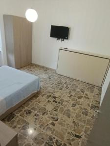 Un dormitorio con una cama y un televisor de pantalla plana. en Fillak home, en Génova