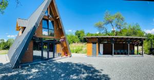 a wooden house with a gambrel roof at Cabana A-Frame Ariana in Porumbacu de Sus