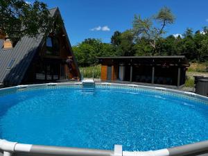 a large swimming pool in front of a house at Cabana A-Frame Ariana in Porumbacu de Sus