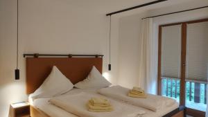 a bedroom with a bed with two towels on it at Fewo Sonntagshorn in Ruhpolding