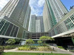 two tall buildings with a courtyard in front of a building at Avida Riala Condotel T4-1103 in Cebu City