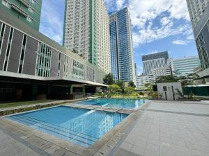 a swimming pool in a city with tall buildings at Avida Riala Condotel T4-1103 in Cebu City