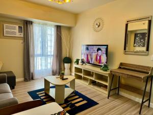 a living room with a couch and a television at Avida Riala Condotel T4-1103 in Cebu City