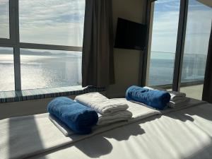 a room with a bed with towels and a large window at Villa Infinia, Lefkada in Sivota +27 photos