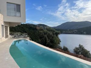 a swimming pool with a view of a body of water at Villa Infinia, Lefkada in Sivota