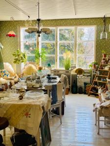 ein großer Raum mit Tischen und Stühlen und Fenstern in der Unterkunft Villa Vintage B&B in Nauvo