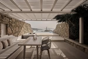 a table and a chair on a patio at Ovea Mykonos in Mikonos