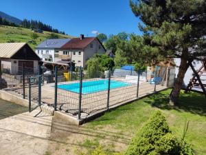 a fence around a swimming pool in a yard at Penzion Leštiny in Dolný Kubín