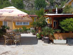 a patio with a table and an umbrella and plants at IN Kala in Rijeka