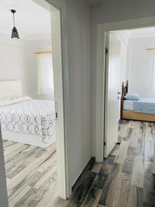 a white bedroom with a bed and a mirror at Rahat Ev in Bodrum City