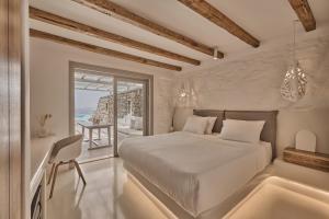 a bedroom with a bed and a view of the ocean at Ovea Mykonos in Mikonos +114 photos