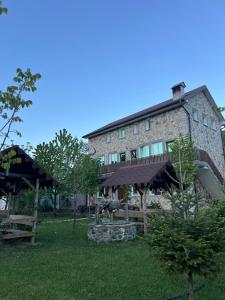 duży kamienny budynek ze stołem piknikowym przed nim w obiekcie Guesthouse Makry w mieście Pukë