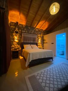 a bedroom with a bed and a stone wall at Luxury Stone House With Turkish Hamam, Sauna, İndoor and Outdoor Pool in Fethiye in Mugla +70 photos