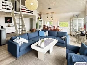 ein Wohnzimmer mit einem blauen Sofa und einem Tisch in der Unterkunft 9 person holiday home in Korshamn-By Traum in Korshamn + 21 Fotos