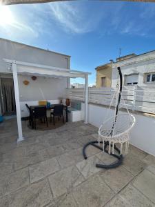 a patio with a hammock on the roof of a house at Casa Vacanza Le Dune- Sole in Maruggio