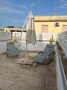 an umbrella and two chairs on a roof at Casa Vacanza Le Dune- Sole in Maruggio +4 photos