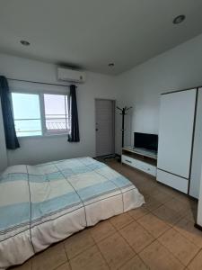 سرير أو أسرّة في غرفة في Merit Courtyard Suvarnabhumi House