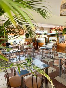 a restaurant with tables and chairs and plants at Kokosek Pokoje Gościnne in Mielno