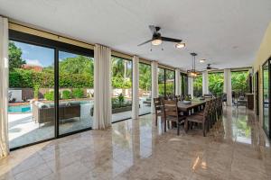 una sala da pranzo con tavolo, sedie e finestre di Luxury 8-BR Villa w Pool Soccer - 20 Guests a Largo